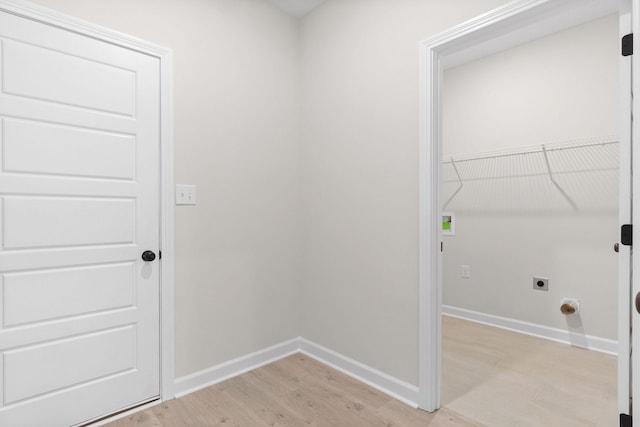 clothes washing area featuring hookup for an electric dryer and light wood-type flooring