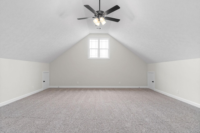 bonus room featuring ceiling fan, lofted ceiling, carpet, and a textured ceiling