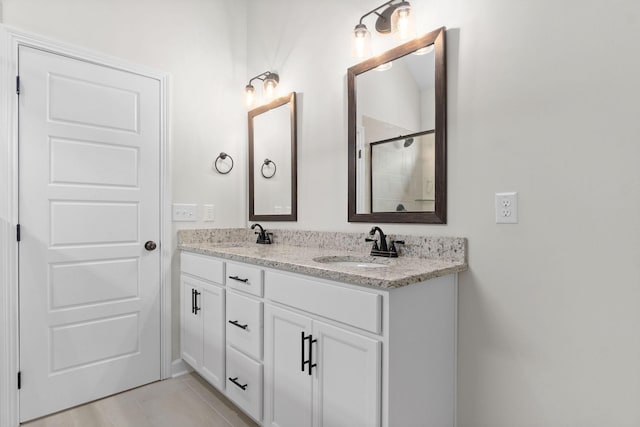 bathroom with vanity, a shower with shower door, and tile patterned floors