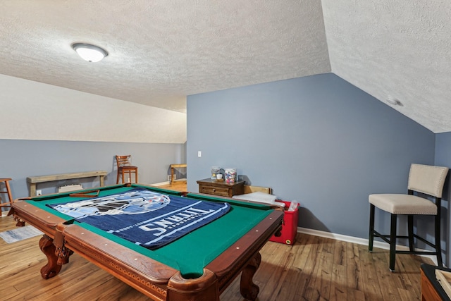 rec room featuring vaulted ceiling, hardwood / wood-style floors, and a textured ceiling