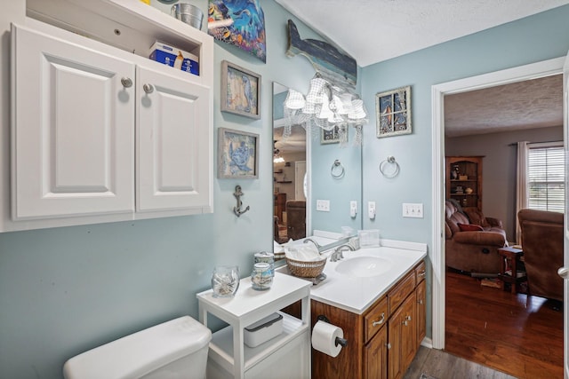 bathroom with vanity, hardwood / wood-style floors, a textured ceiling, and toilet