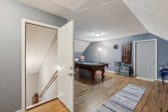 recreation room with vaulted ceiling, billiards, hardwood / wood-style floors, and a textured ceiling