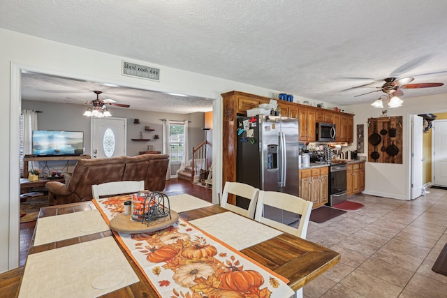 dining room featuring light tile patterned flooring, ceiling fan, and a textured ceiling