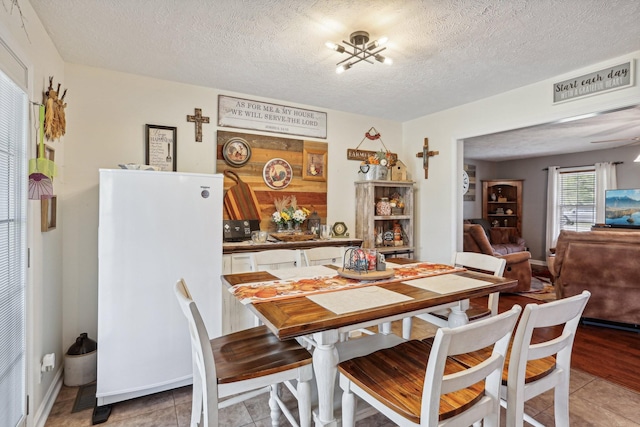 tiled dining room with a textured ceiling