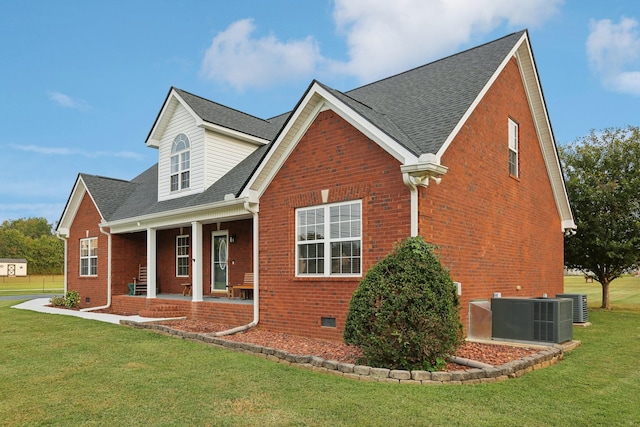 view of front facade with central AC, a front yard, and a porch