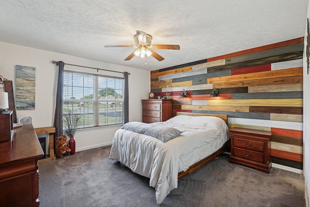 bedroom featuring dark colored carpet, ceiling fan, a textured ceiling, and wooden walls