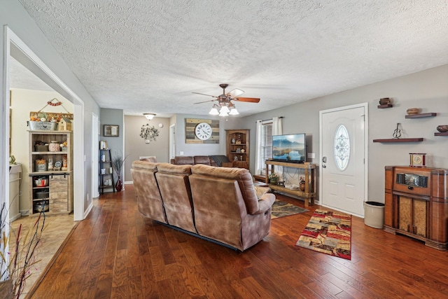 living room with ceiling fan, dark hardwood / wood-style floors, and a textured ceiling