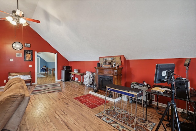 living room with lofted ceiling, hardwood / wood-style flooring, and ceiling fan