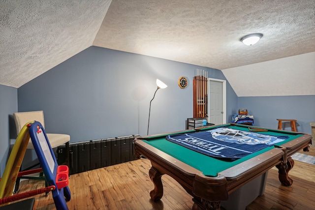 game room featuring hardwood / wood-style floors, pool table, vaulted ceiling, and a textured ceiling