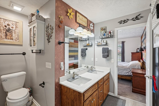 bathroom featuring vanity, toilet, and a textured ceiling