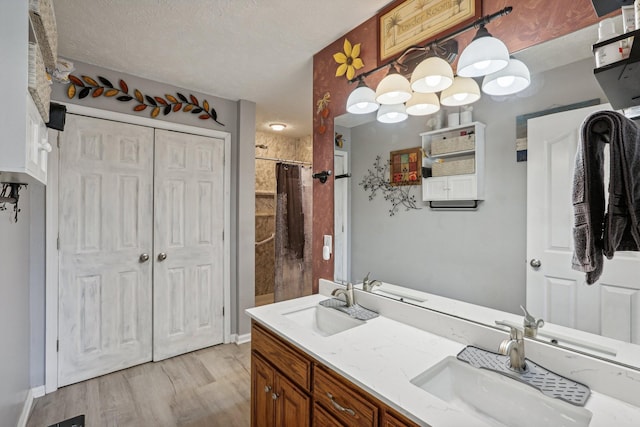 bathroom with vanity, wood-type flooring, a textured ceiling, and a shower with shower curtain