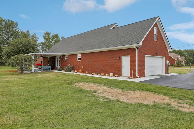 rear view of property featuring a garage and a lawn