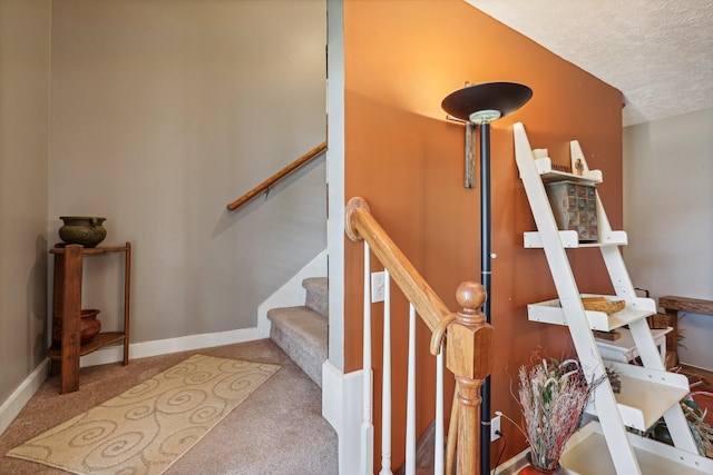 stairs with carpet and a textured ceiling