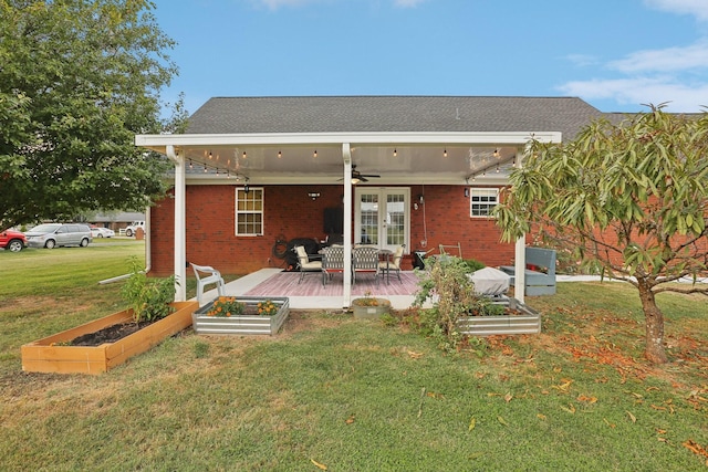 rear view of property featuring a wooden deck, a lawn, and ceiling fan