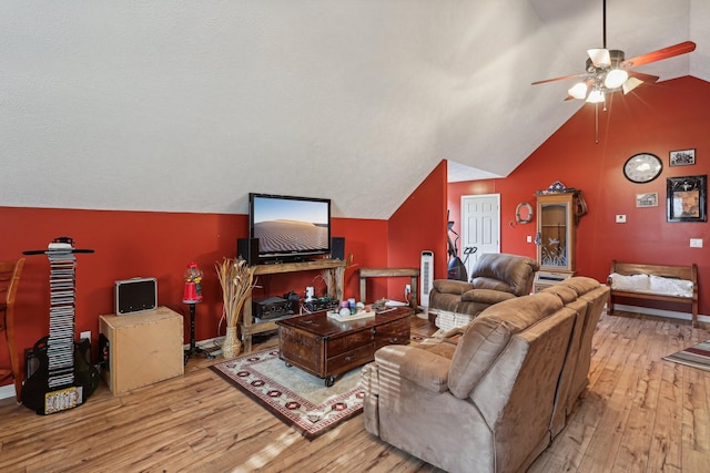 living room with ceiling fan, lofted ceiling, and light wood-type flooring