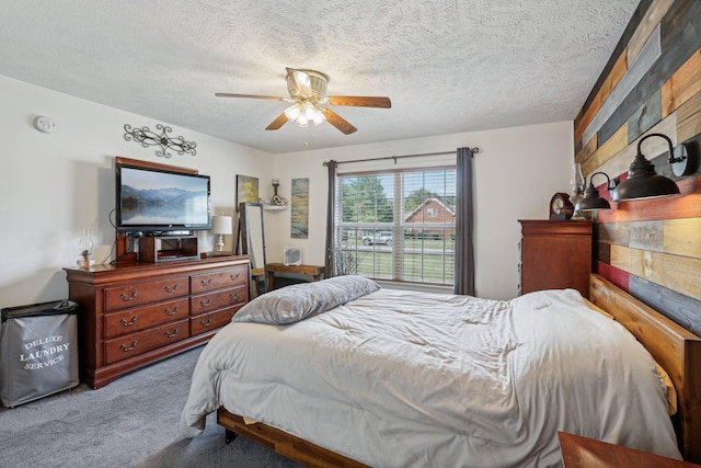 bedroom with ceiling fan, a textured ceiling, and carpet flooring