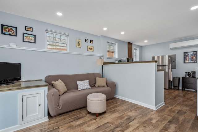 living room featuring wood-type flooring and a wall mounted AC