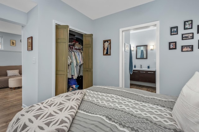 bedroom featuring hardwood / wood-style floors, ensuite bath, and a closet