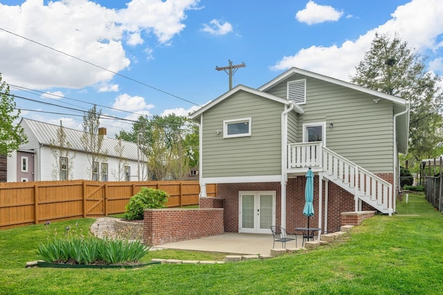 rear view of house with a patio area, french doors, and a lawn