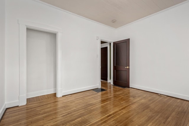 unfurnished bedroom with crown molding and hardwood / wood-style floors