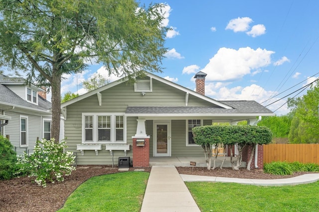 view of front of house with covered porch and a front lawn