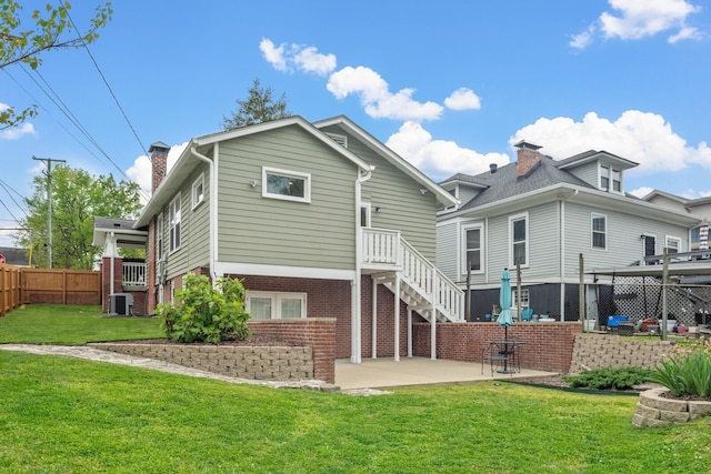 rear view of property featuring central AC, a patio, and a lawn