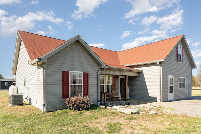 view of front facade with a front lawn and central air condition unit