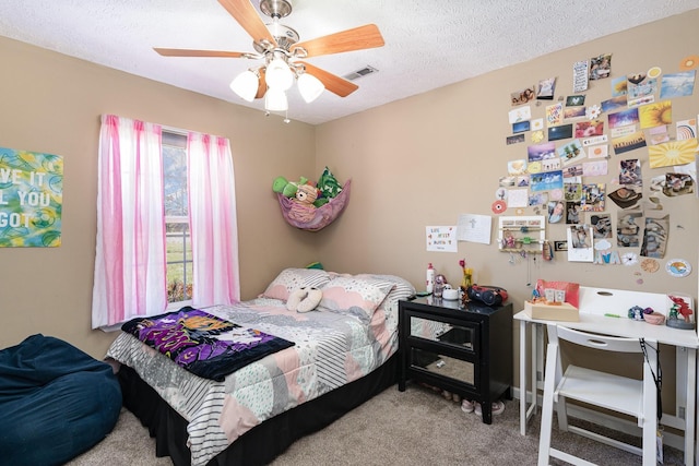 carpeted bedroom featuring ceiling fan and a textured ceiling