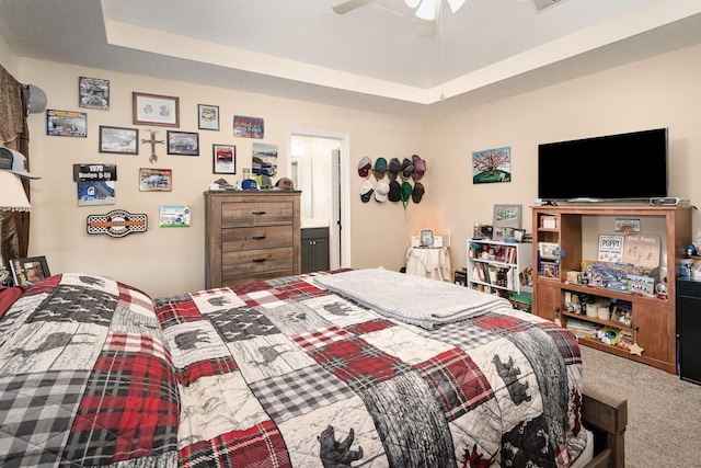 bedroom with carpet floors, ceiling fan, and a tray ceiling