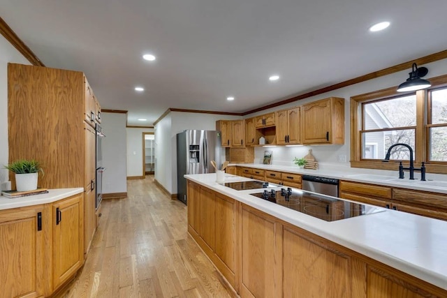 kitchen featuring ornamental molding, stainless steel appliances, sink, and light wood-type flooring