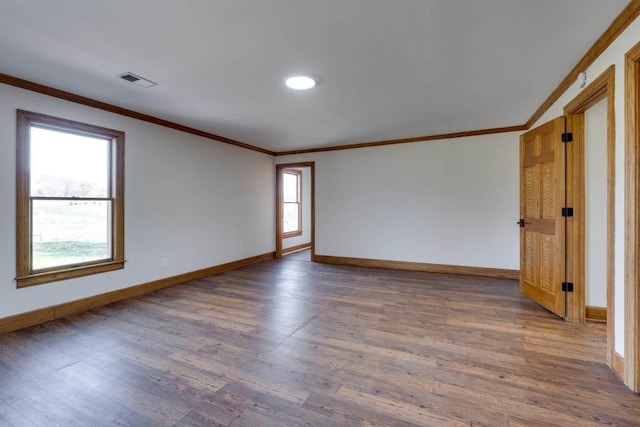 spare room featuring ornamental molding and dark hardwood / wood-style floors