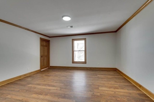 empty room with wood-type flooring and ornamental molding