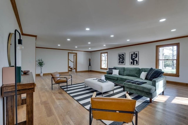 living room with ornamental molding, plenty of natural light, and light hardwood / wood-style floors