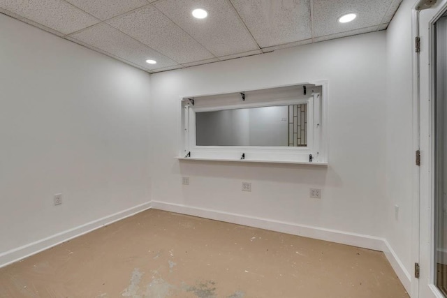 unfurnished room with concrete floors and a drop ceiling