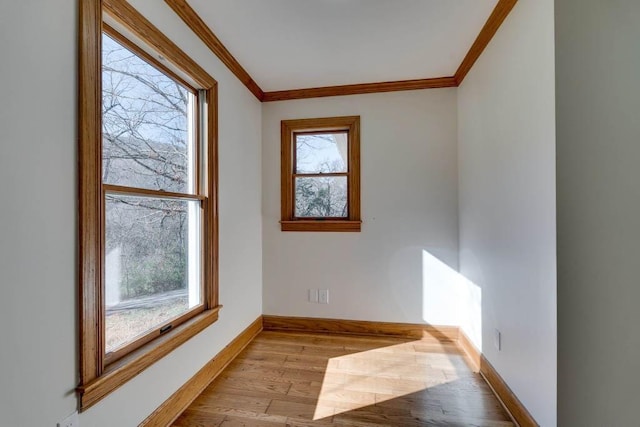 unfurnished room featuring ornamental molding and light hardwood / wood-style floors