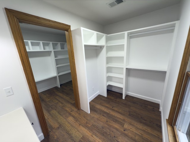 walk in closet with dark hardwood / wood-style flooring