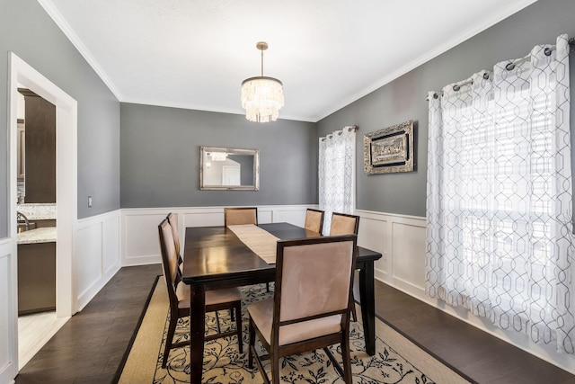 dining room with a notable chandelier, crown molding, and dark wood-type flooring