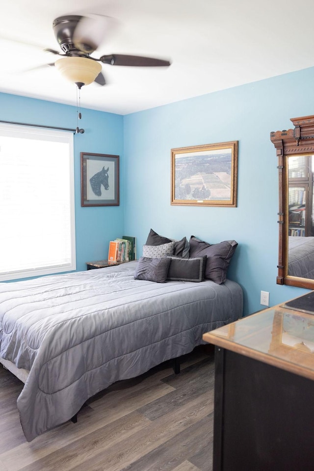 bedroom with ceiling fan and dark hardwood / wood-style flooring