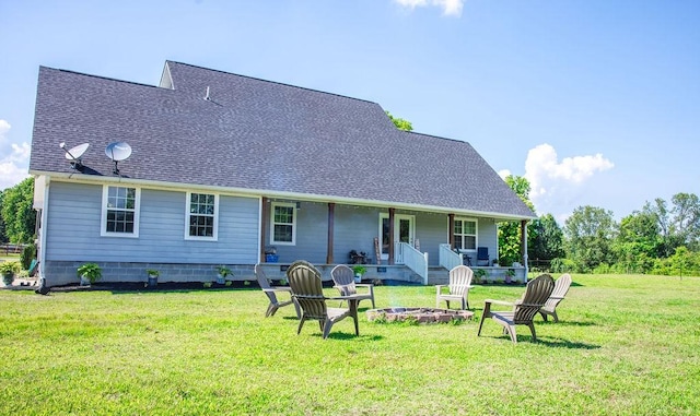 rear view of house featuring a yard, a porch, and an outdoor fire pit