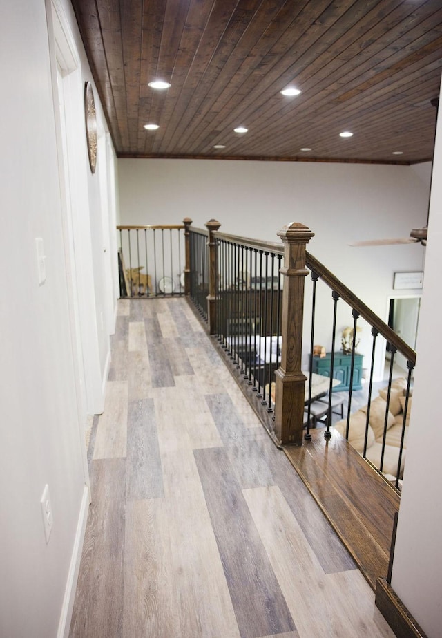 hallway with light wood-type flooring and wooden ceiling