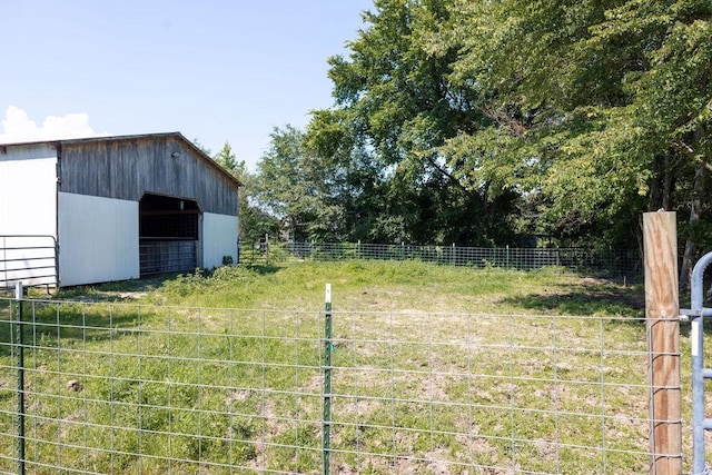 view of yard with an outdoor structure and a rural view