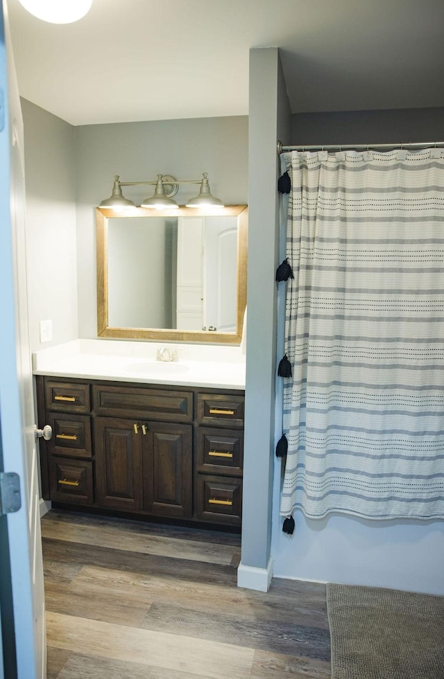 bathroom with vanity, hardwood / wood-style floors, and shower / tub combo