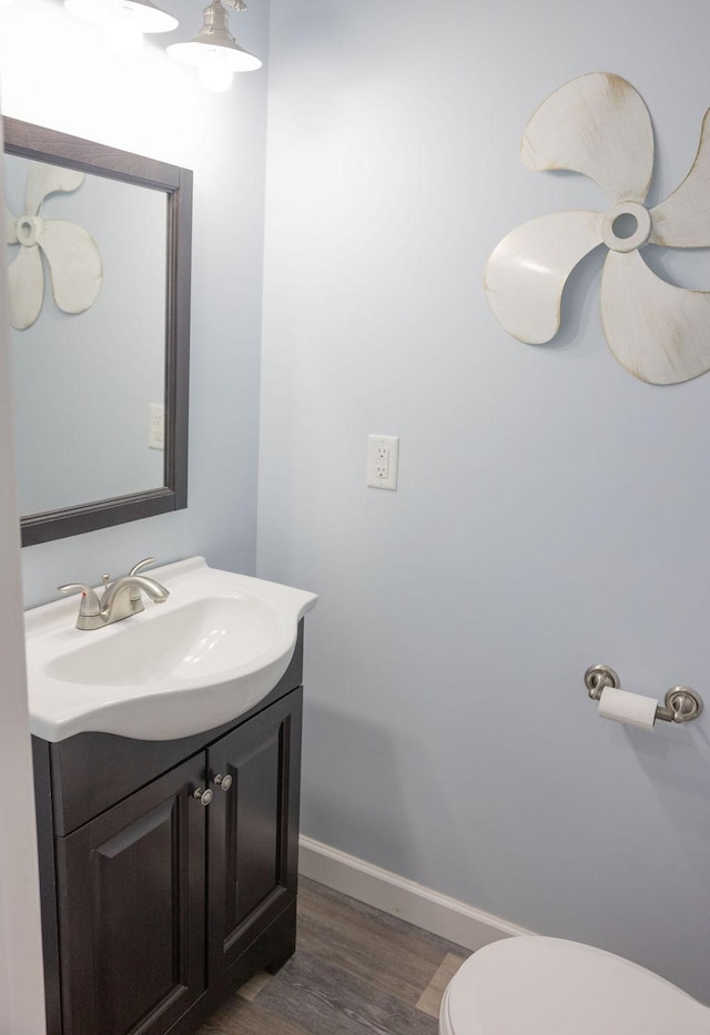 bathroom featuring vanity, hardwood / wood-style floors, and toilet