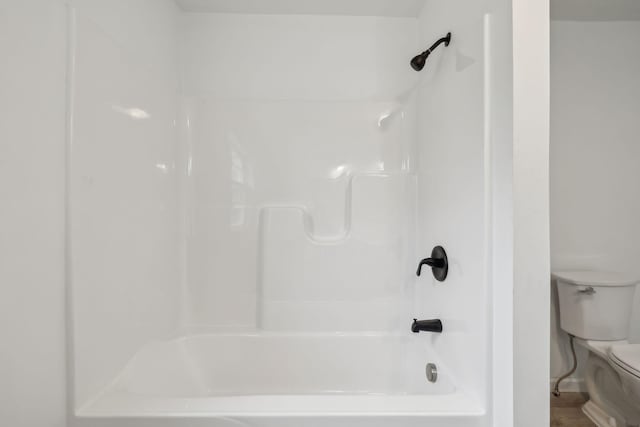 bathroom featuring bathtub / shower combination and toilet