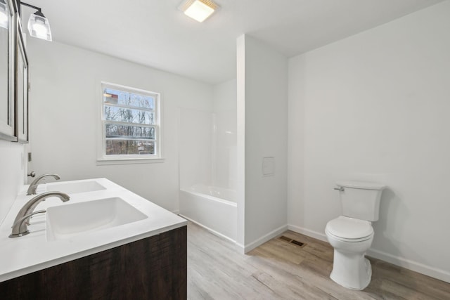 bathroom featuring vanity, hardwood / wood-style flooring, and toilet