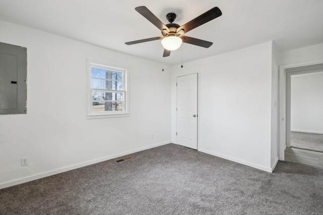 unfurnished room with dark colored carpet, electric panel, and ceiling fan