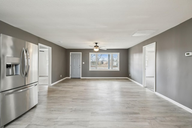 interior space featuring a textured ceiling, ceiling fan, and light wood-type flooring