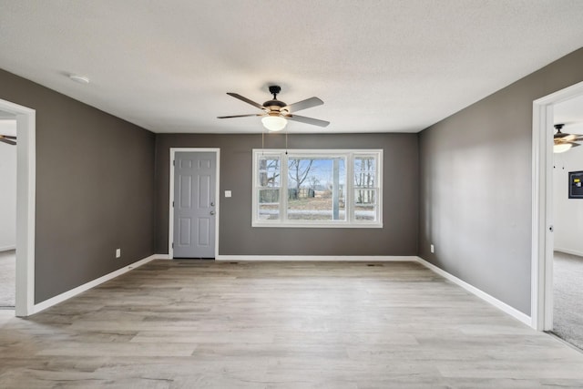 unfurnished room featuring a textured ceiling, ceiling fan, and light hardwood / wood-style floors