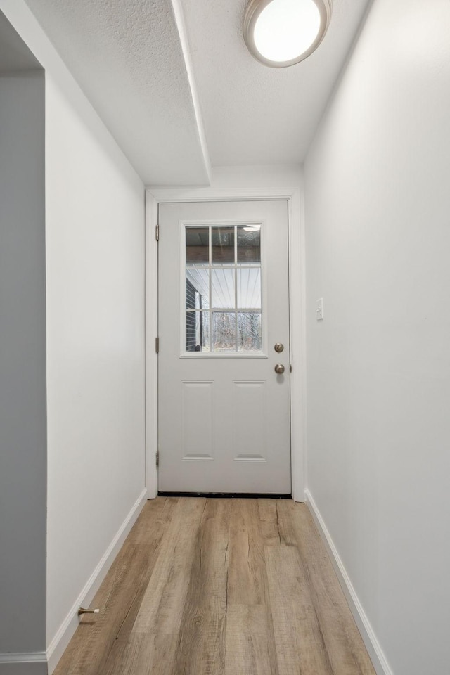 entryway with a textured ceiling and light wood-type flooring