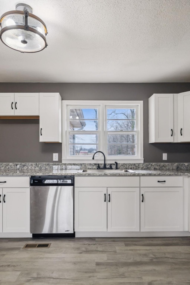 kitchen with white cabinetry, dishwasher, and sink